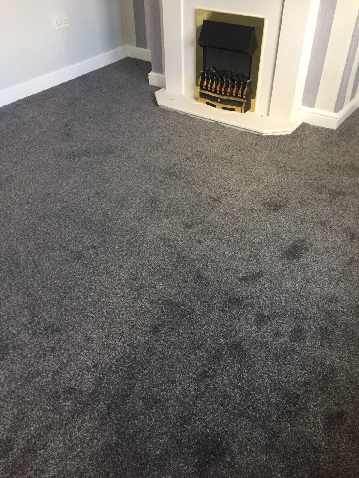 grey carpet in living room around fireplace