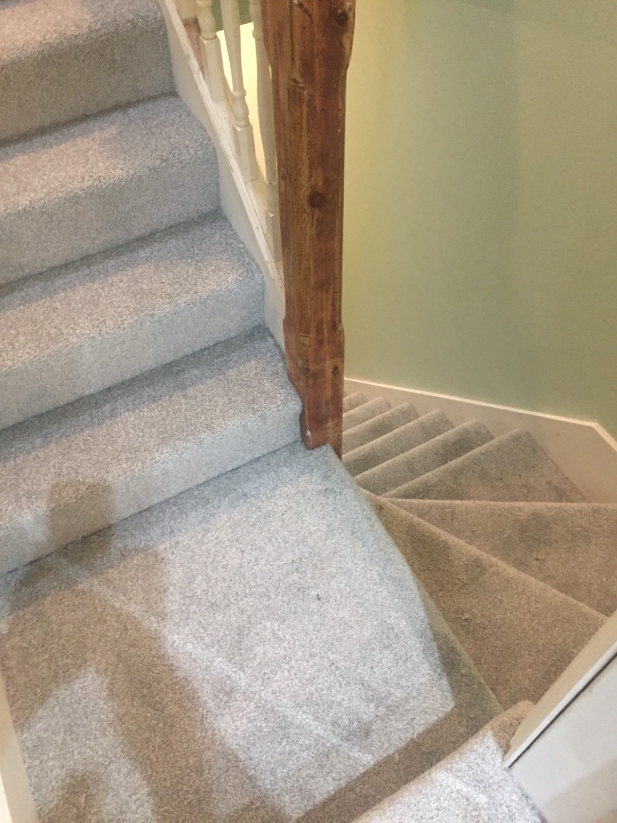 silver carpet fitted on staircase with brown banister
