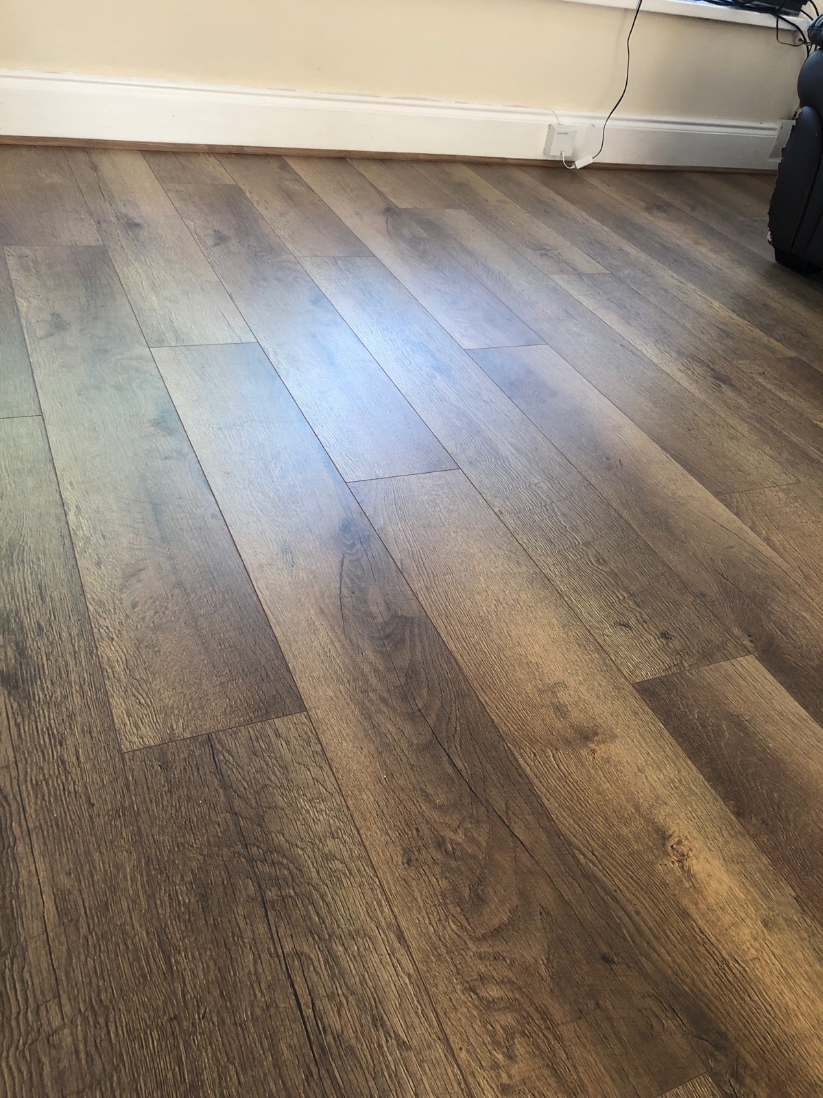 close up of dark brown and grey mixed laminate flooring fitted in living room