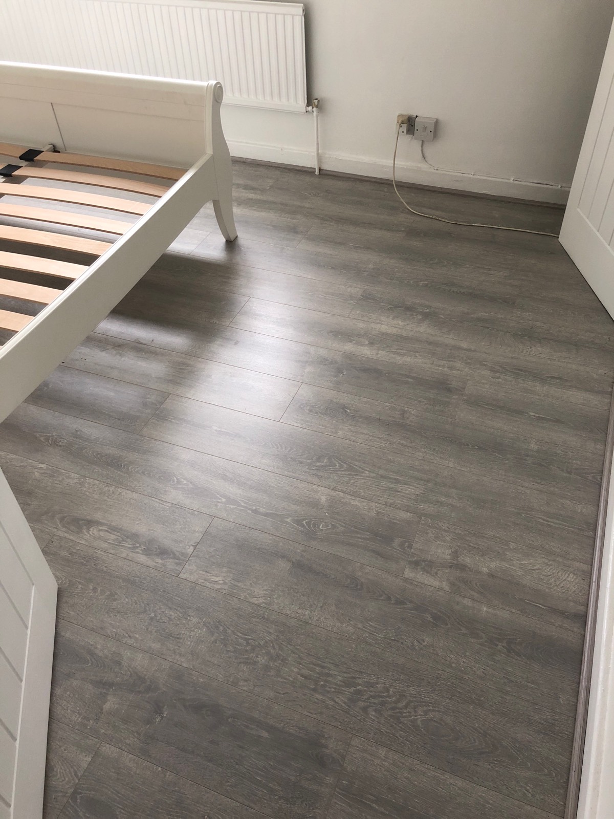 dark grey laminate flooring fitted in bedroom